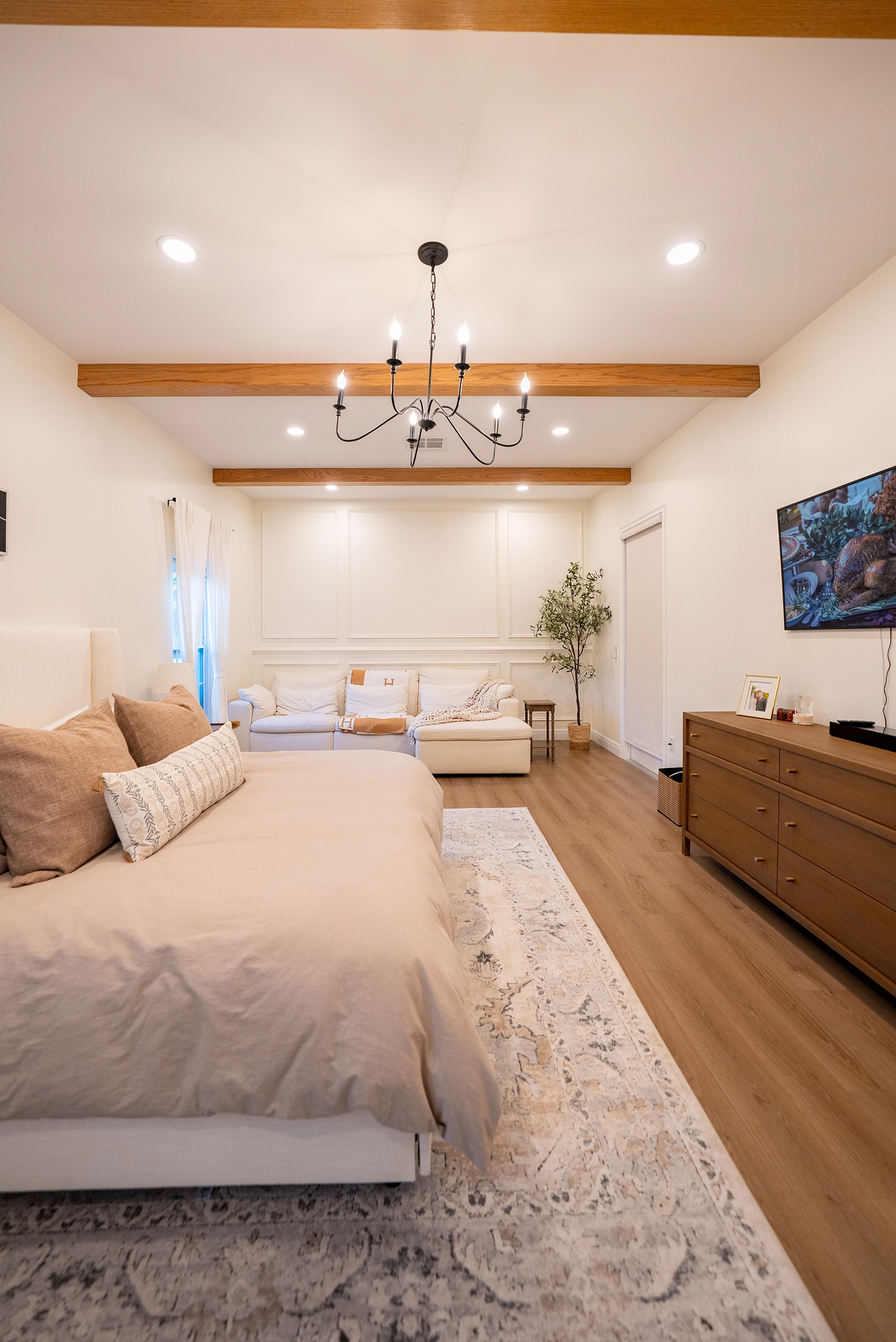 Luxury bedroom remodel showcasing neutral decor, a large area rug, and ample natural light.