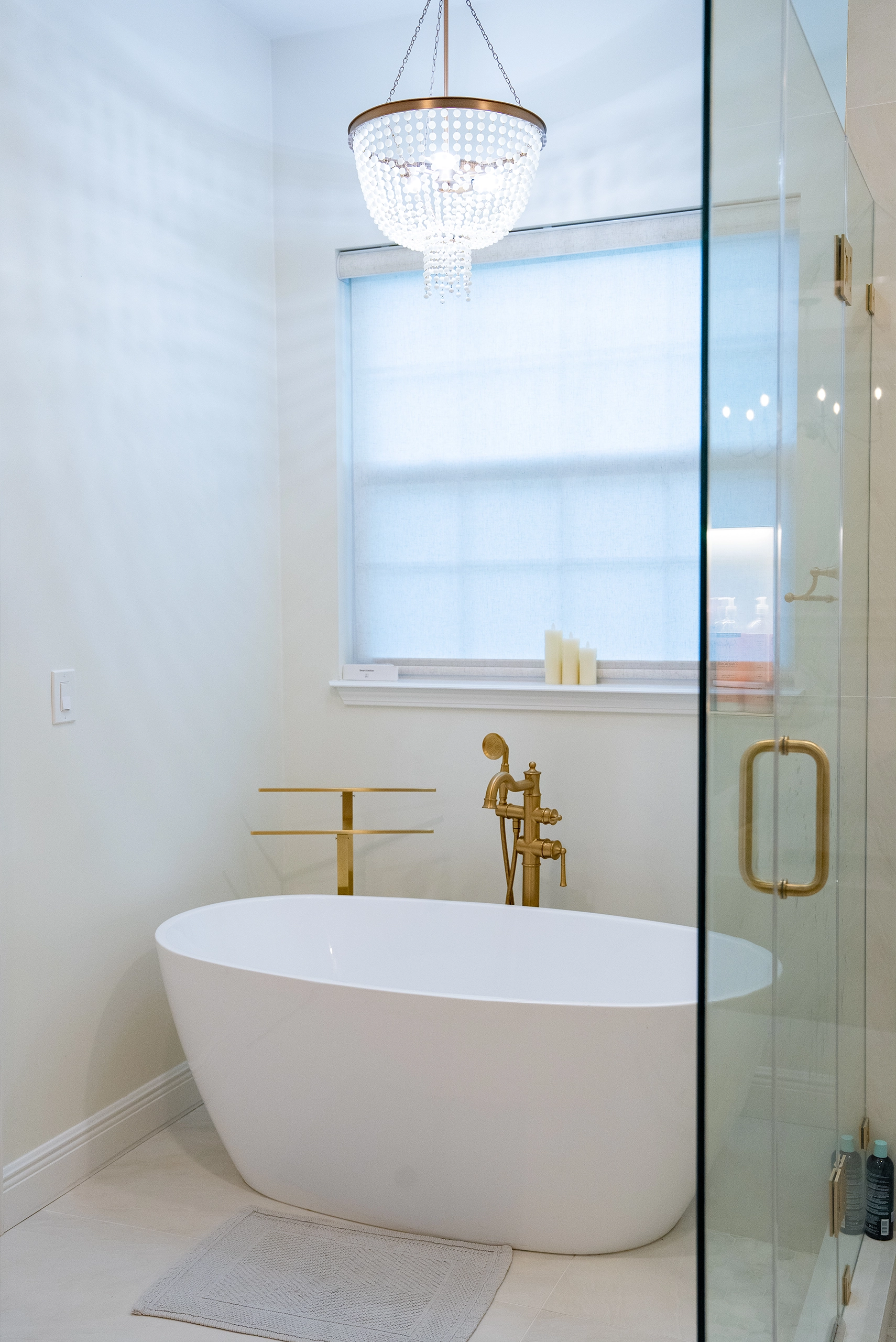 Modern bathroom design showcasing brass fixtures, a deep soaking tub, and tile flooring.