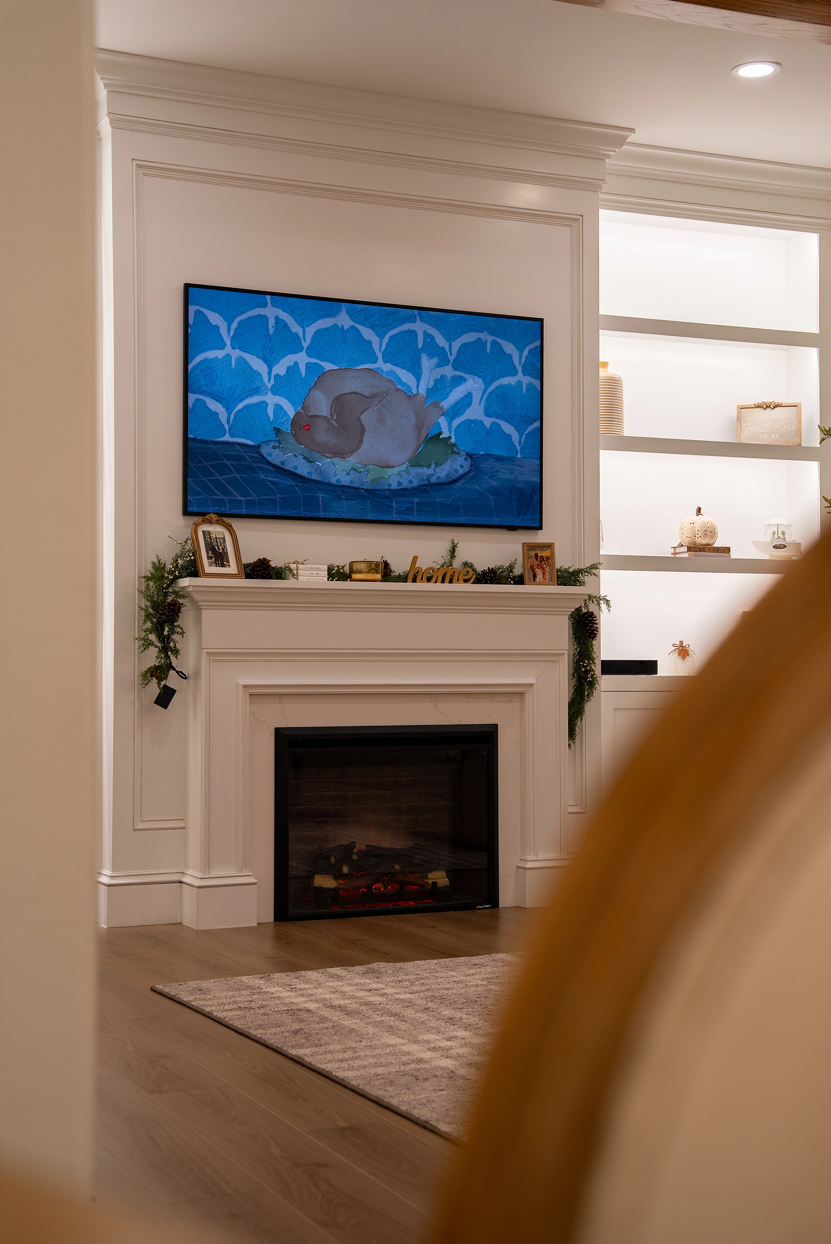 Cozy living space featuring a styled fireplace mantel and recessed shelving with decorative accessories.