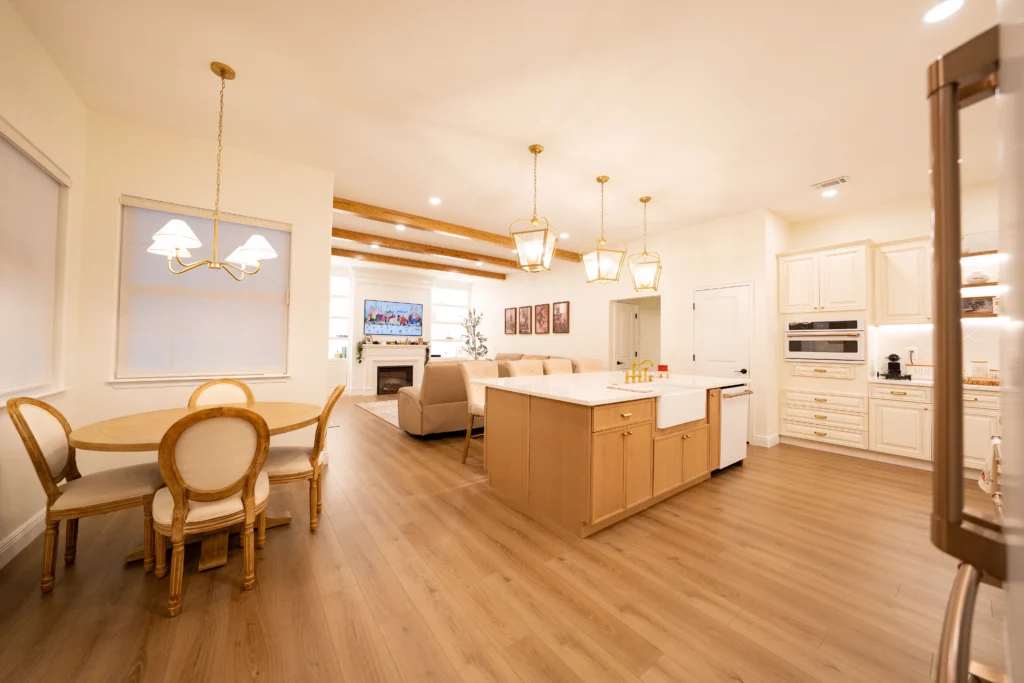 Open-concept modern farmhouse kitchen featuring a large island with a white farmhouse sink overlooking the adjoining living area